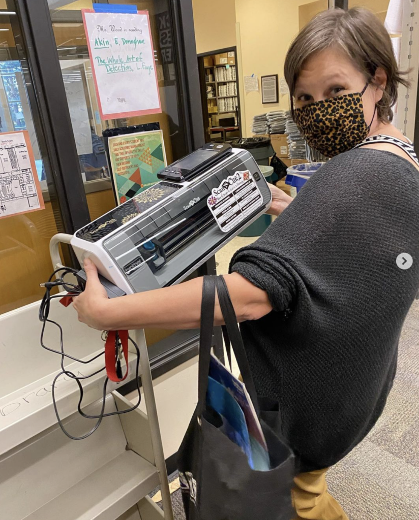 Teacher in the library holding a 3D printer