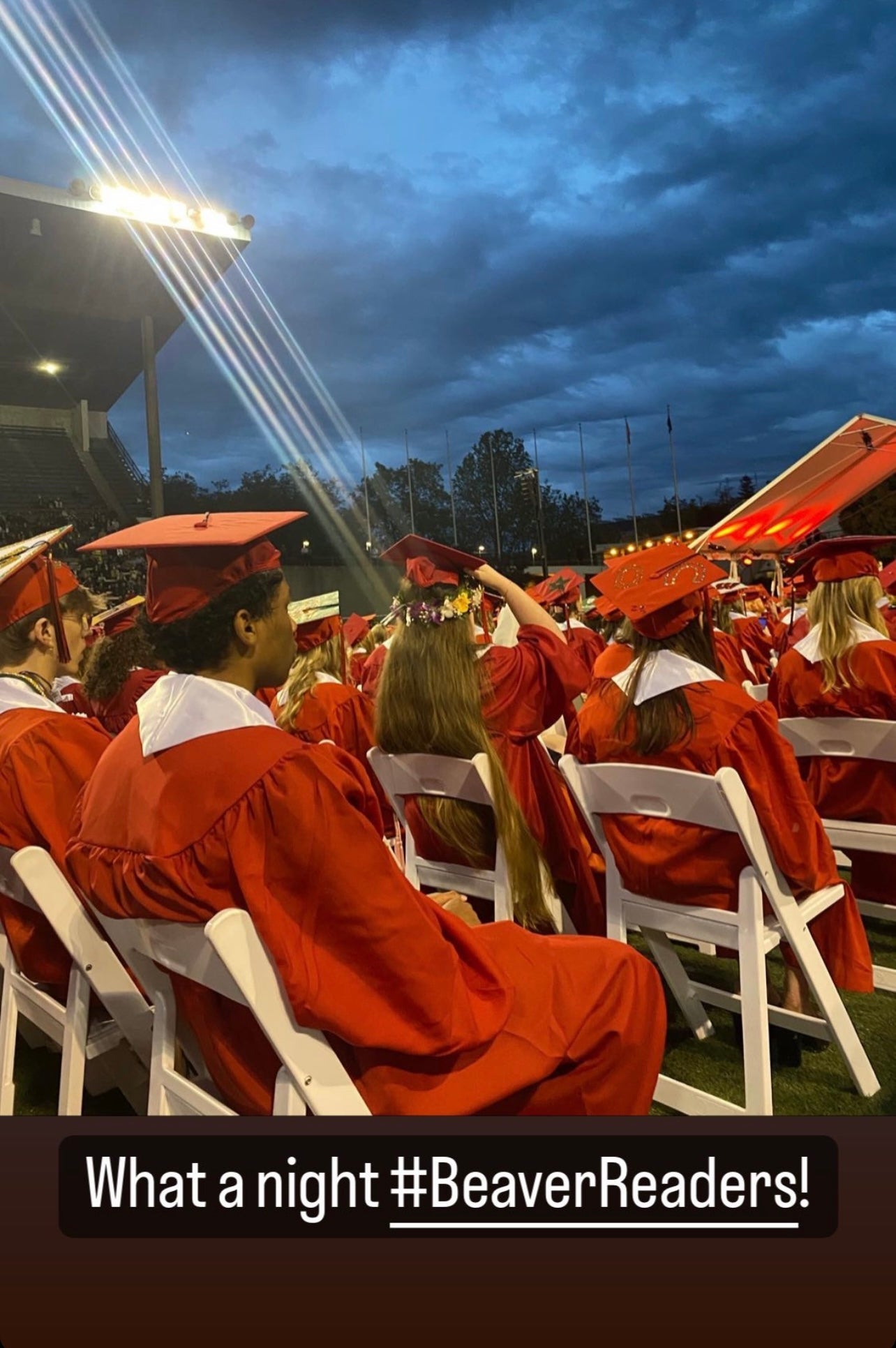 Graduates in Red Gowns in chairs at Memorial Stadium