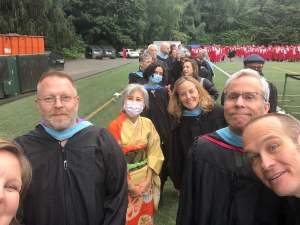 BHS Staff Selfie and line of students in red cap and gown