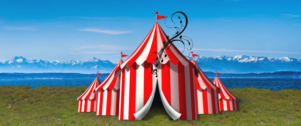 Red and White striped tent with musical notes on the grass in front of the snow covered mountains