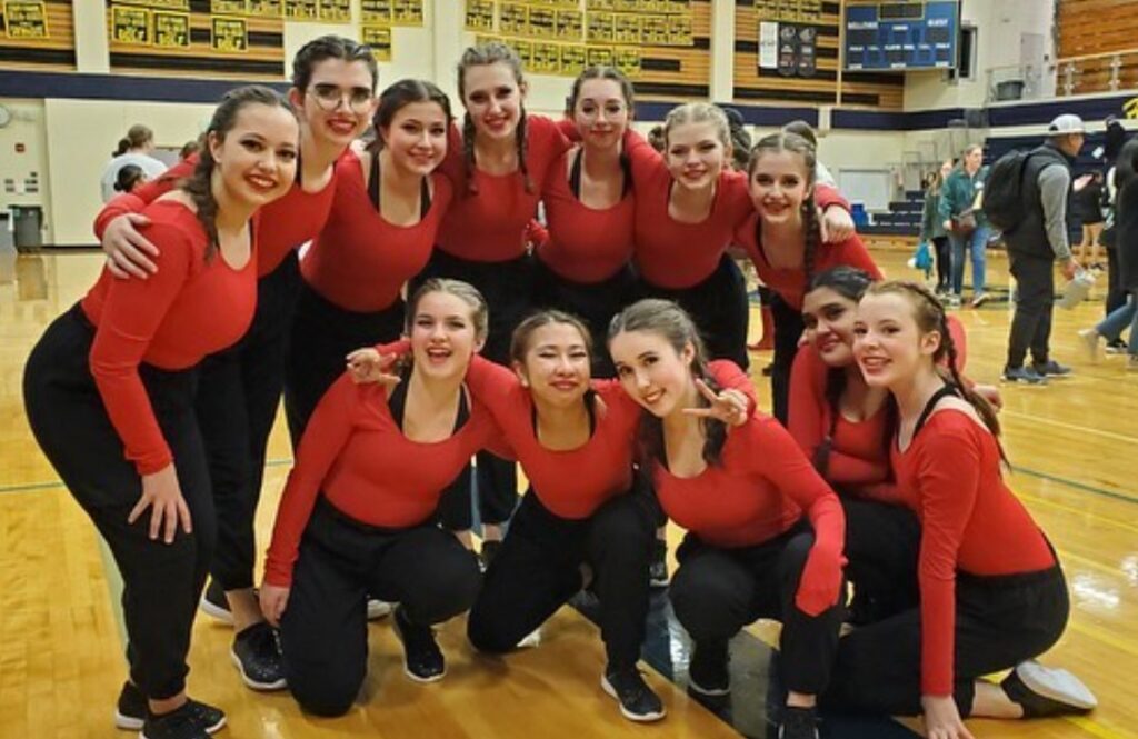 Dance Team in gym wearing red tops and black pants