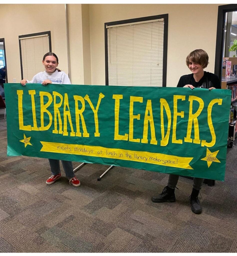 Library Leaders Sign with Students holding it up